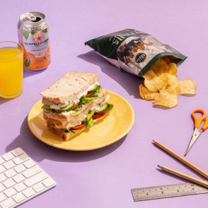 Styled photography of a sandwich, crisps and drinks