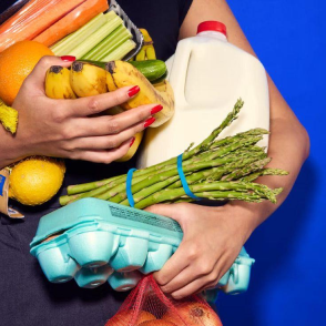 Person holding a bundle of fresh groceries