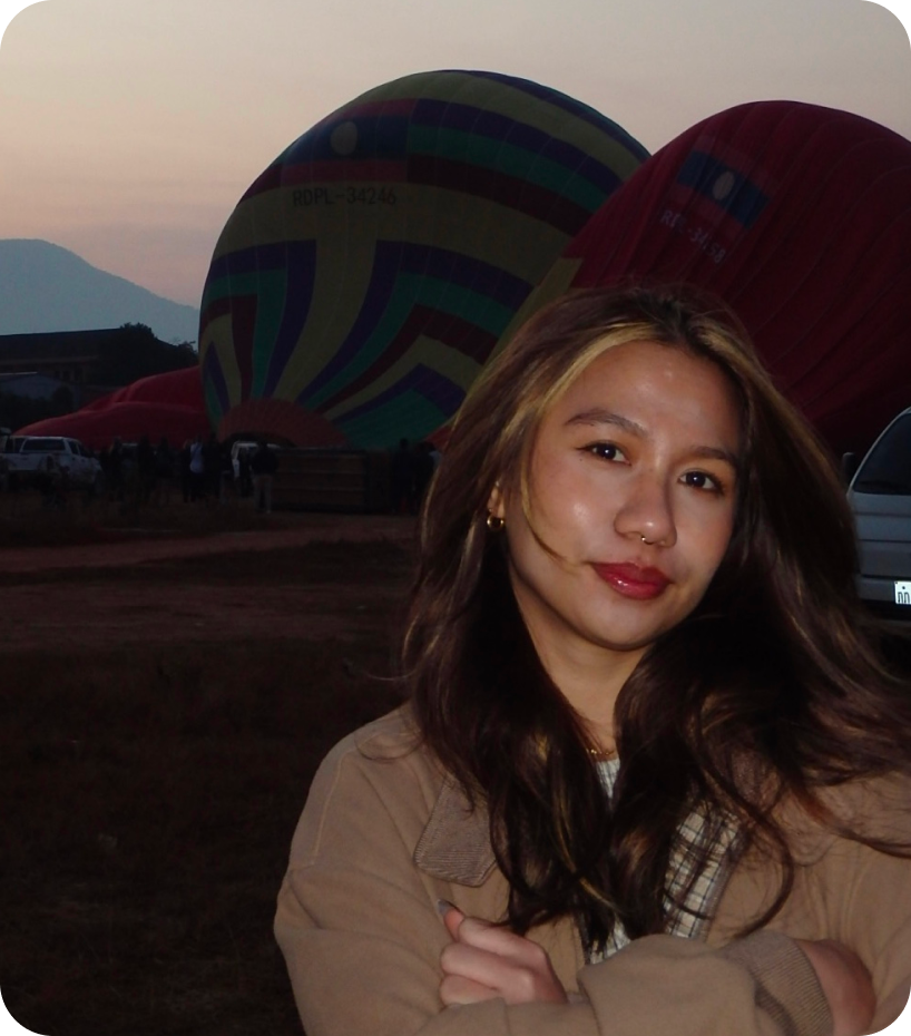 Toni Francine standing in front of hot air balloons at sunrise